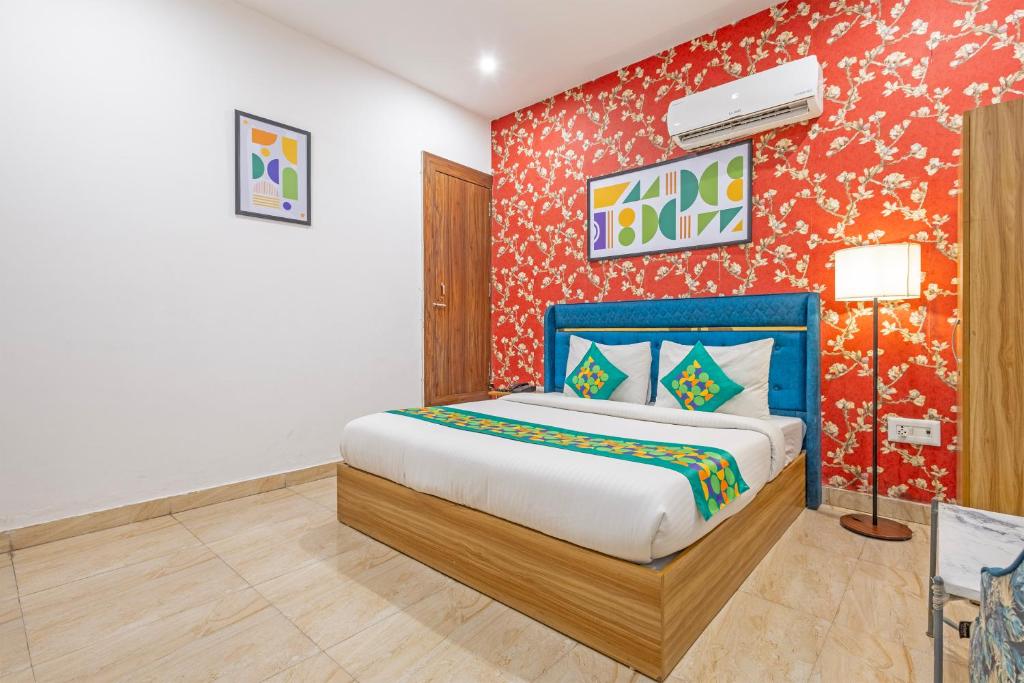 a bedroom with a bed and a red wall at Treebo Noida Business Suites in Okhla