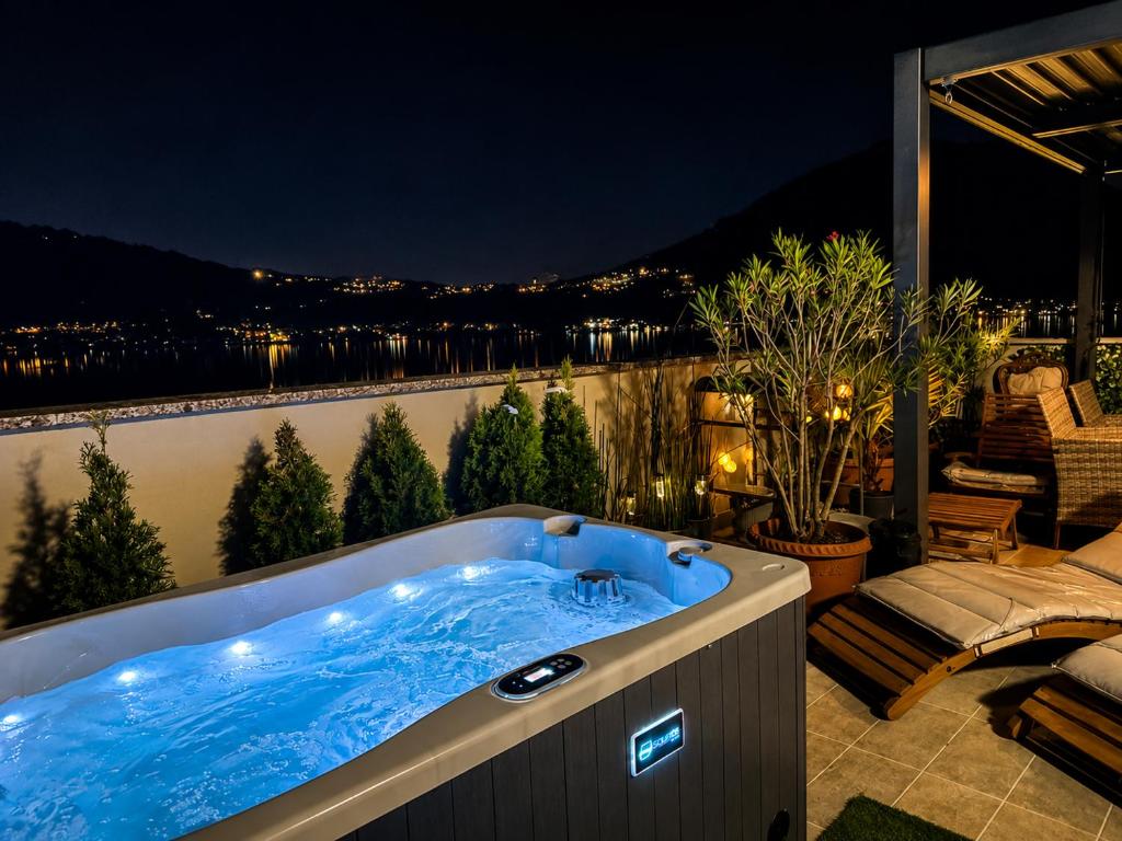 a hot tub on a balcony at night at Felicita Cascata Terrace with Lake View in Lecco