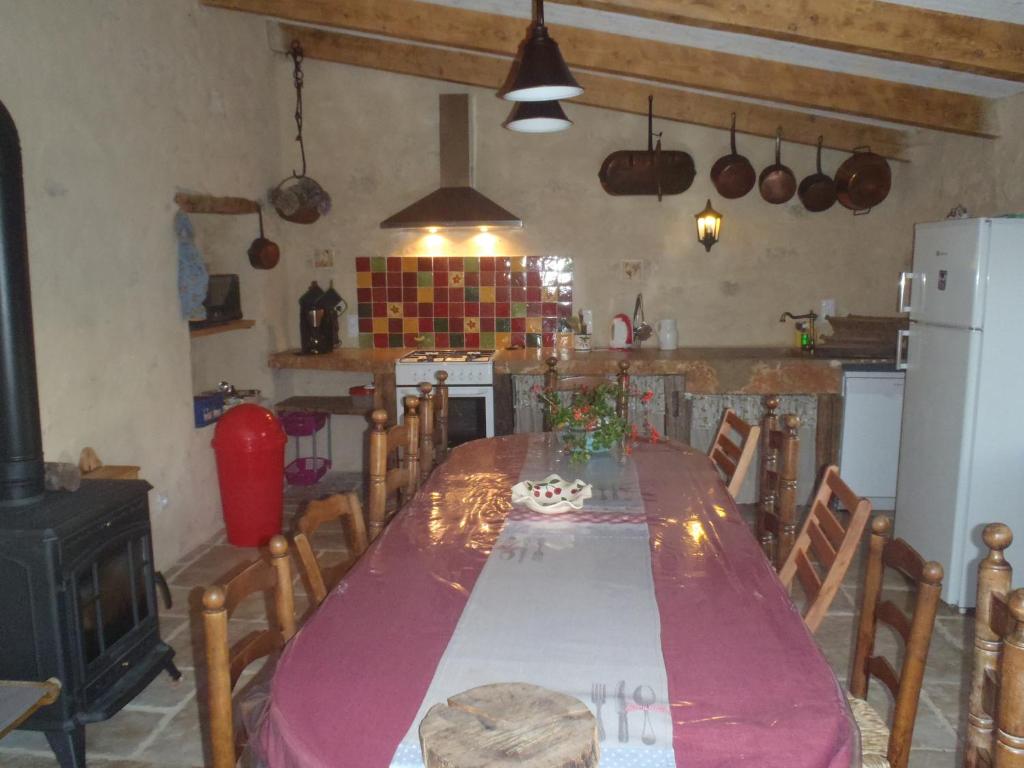 een keuken met een lange tafel in een kamer bij Gite du Domaine de Bombes in Mostuéjouls