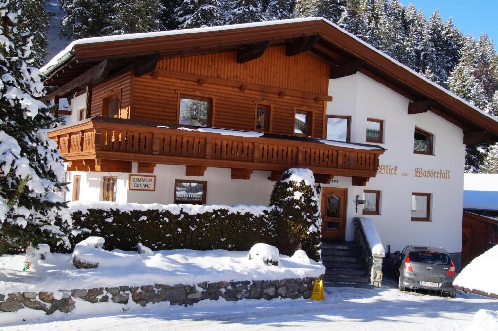 a house in the snow with a car parked in front at Blick zum Wasserfall in Sankt Leonhard im Pitztal