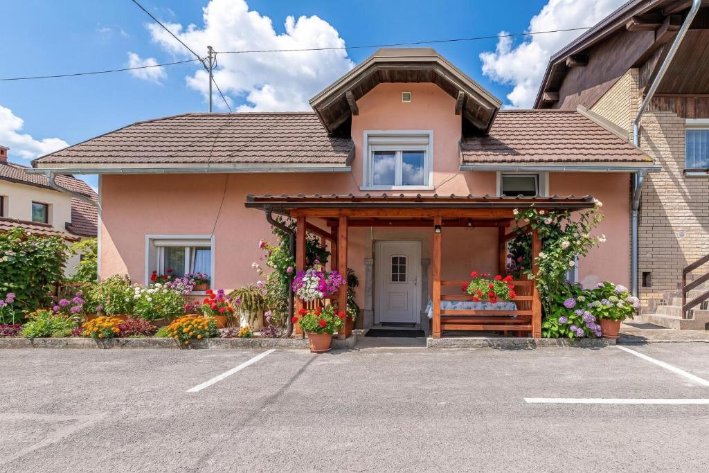 a pink house with flowers in a parking lot at Mržek House with Sauna - Happy Rentals in Nova Vas