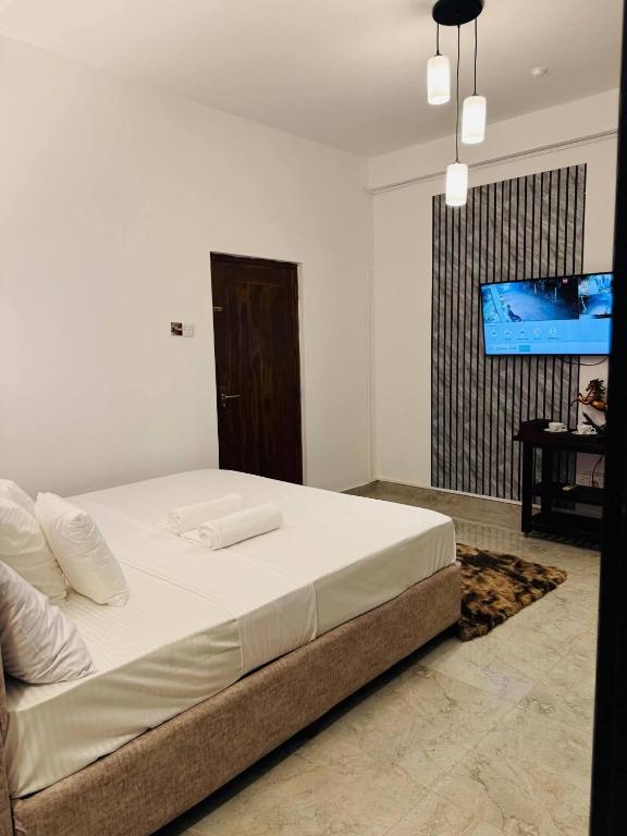 a bedroom with a bed and a flat screen tv at Boom Town Villa - Anuradhapura in Anuradhapura