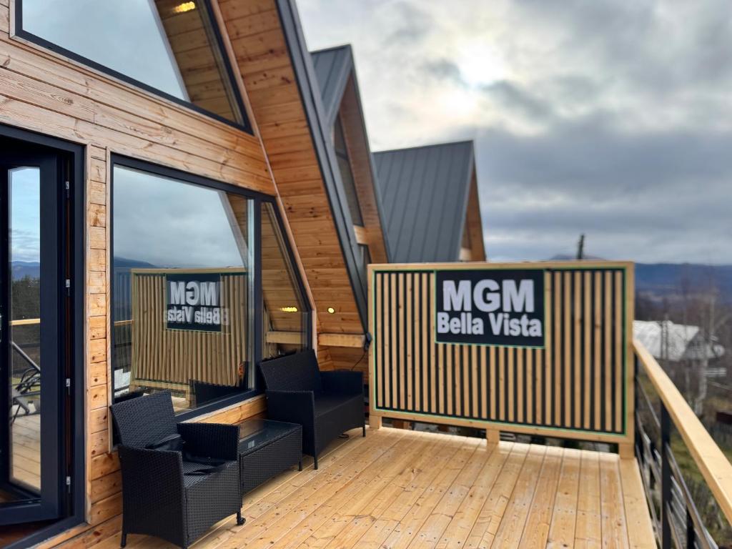 a wooden deck with two chairs on a building at MGM BellaVista in Jieţ