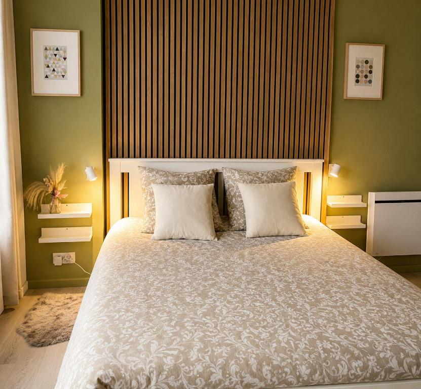a bedroom with a large bed with two pillows at Appartement bien être à Colmar in Colmar