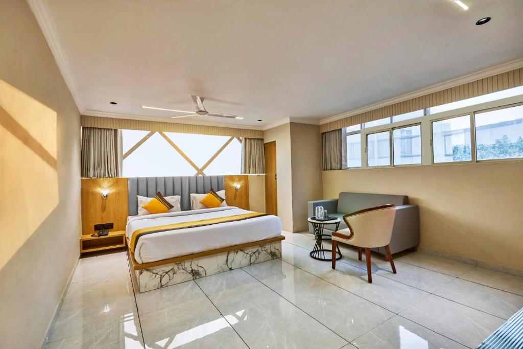 a bedroom with a bed and a desk and a chair at Itsy Hotels Grand CG in Ahmedabad
