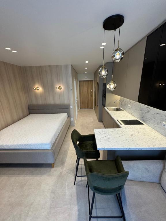 a bedroom with a bed and a desk and a kitchen at S14 Apartment in Vilnius
