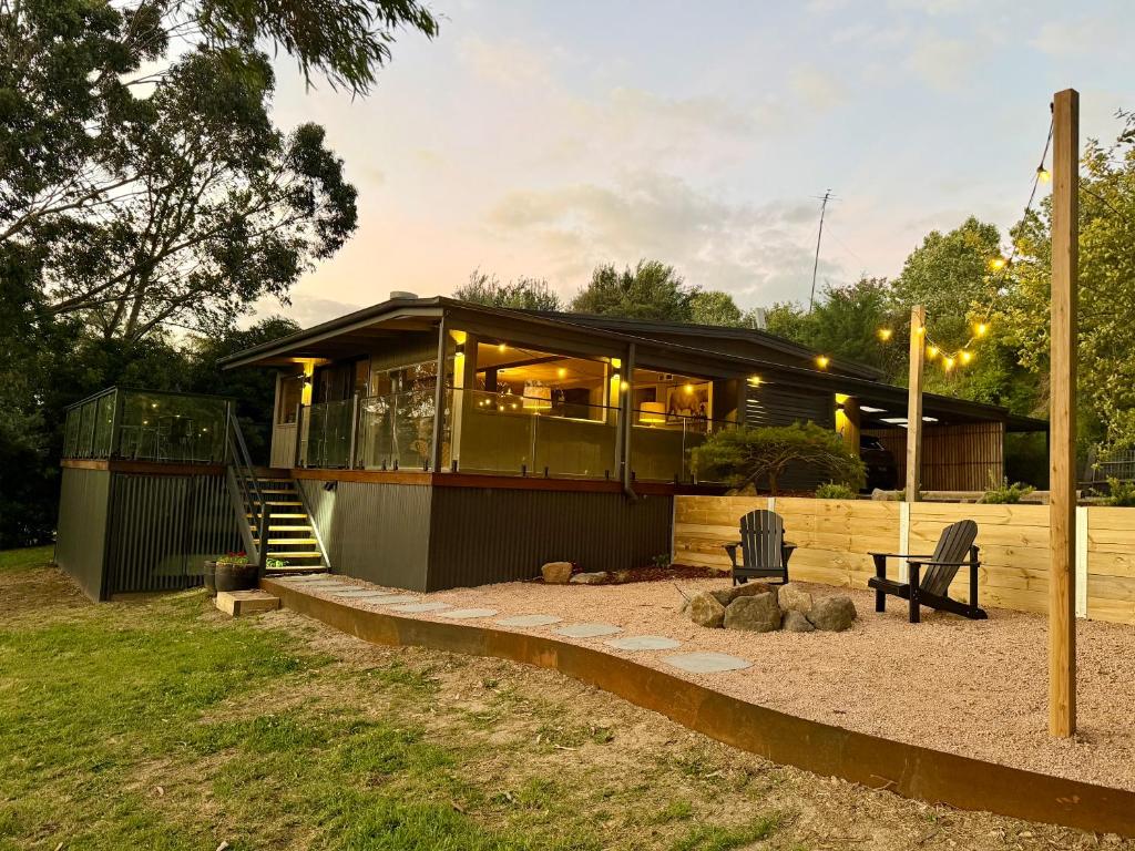 a house with a porch and stairs to it at Stylish 2-Bed Home, Stunning View, Fire Pit, Festoon Lights, BBQ and walk to Pub in Poowong