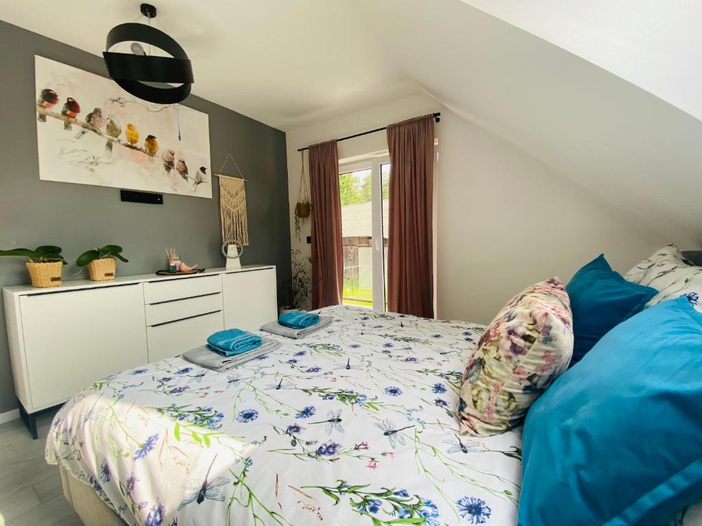 a bedroom with a bed with blue pillows at Apartament Masuria SPA Renata Rosłoń in Świętajno