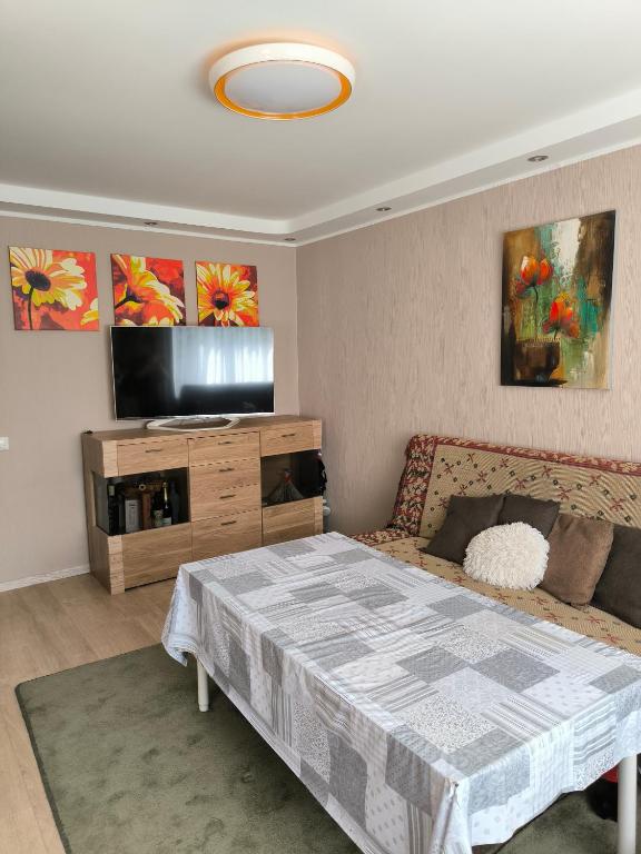 a bedroom with a bed and a flat screen tv at Family Apartament in Narva-Jõesuu