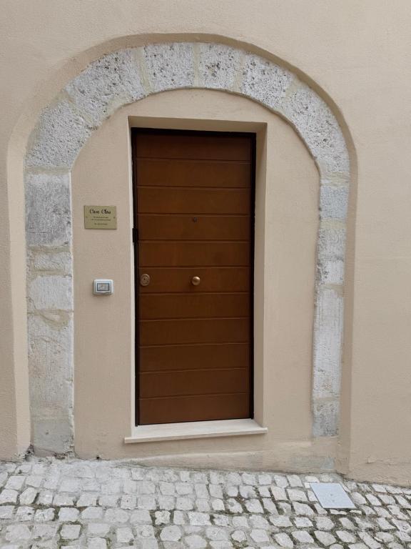 a brown door in a building with an arch at Casa Cloe in LʼAquila