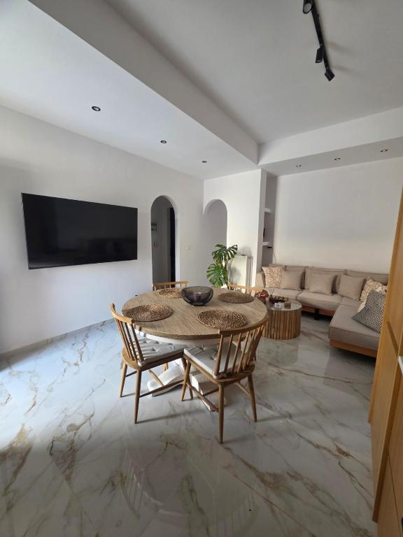a living room with a table and chairs and a couch at Le Blé Home in Mérikhas