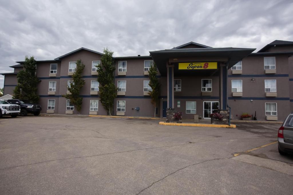 a hotel with a car parked in a parking lot at Super 8 by Wyndham Whitecourt in Whitecourt