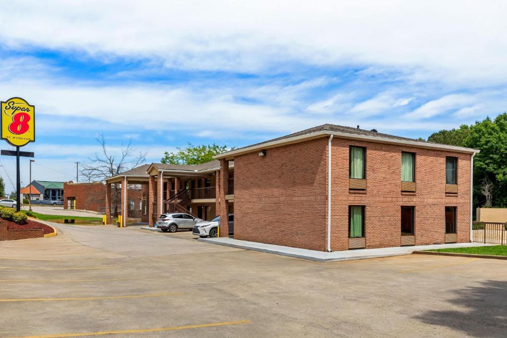 a brick building in a parking lot next to a car at Super 8 by Wyndham Acworth/Atlanta Area in Acworth