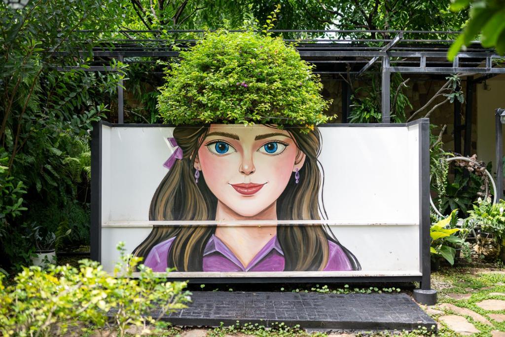 a painting of a woman with a plant on her head at Plerntaan HoReCa in Ban Khlong Kum
