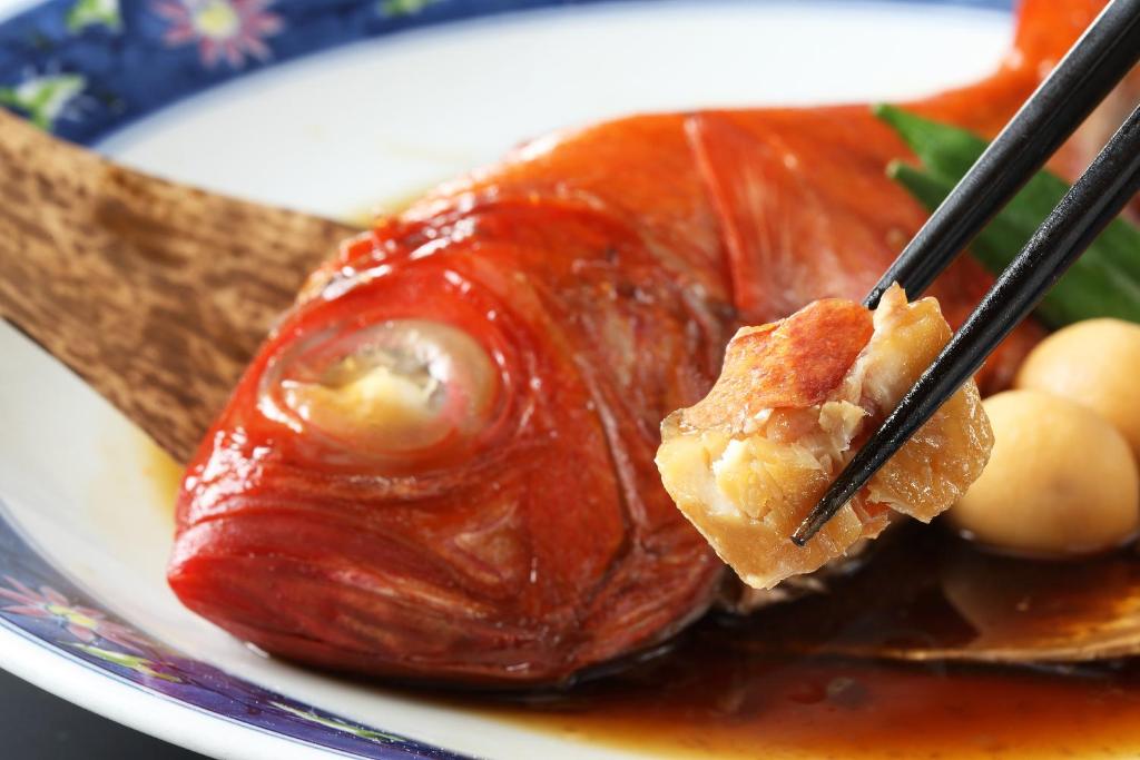 a piece of food on a plate with chop sticks at Ito Kowakien in Ito