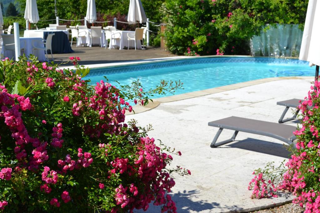 una piscina con flores rosas y un banco en Agriturismo La Dolza, en Follina