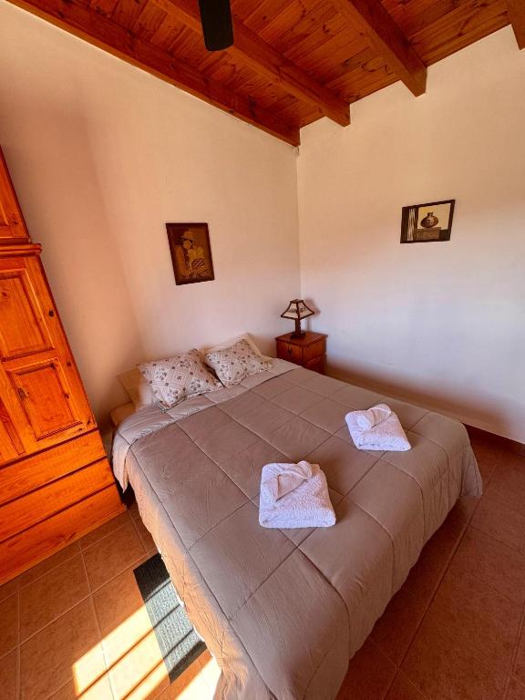 a bedroom with a large bed with towels on it at Luna Vallista Apart Hotel in Seclantás