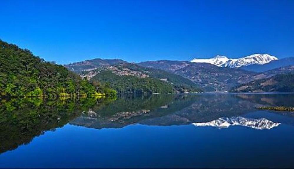 a view of a lake with snow capped mountains at Hotel crunchy shadowbegnas in Deorāli