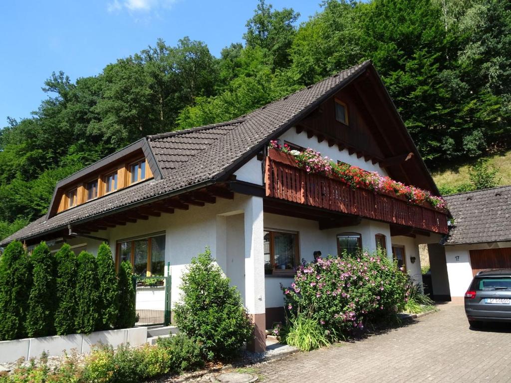 a house with a black roof and flowers at Ferienwohnung Mühlengrün in Oberwolfach