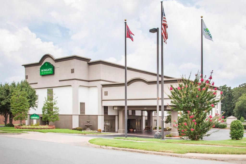 a front view of a hotel with two flags at Wingate by Wyndham North Little Rock in North Little Rock