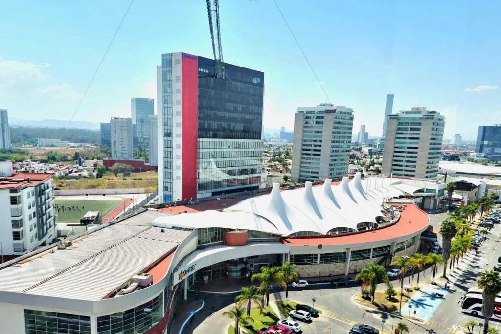 a large building with a white roof in a city at Wyndham Puebla Angelopolis in Puebla