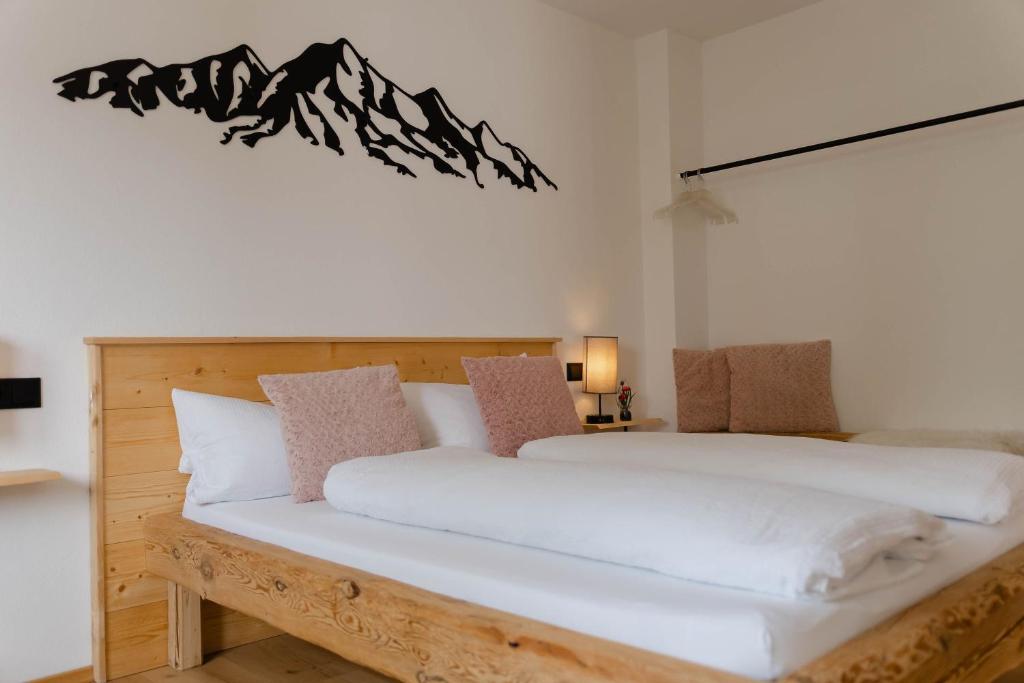 a bedroom with two beds with white sheets at Ferienwohnung Enzian in Halblech