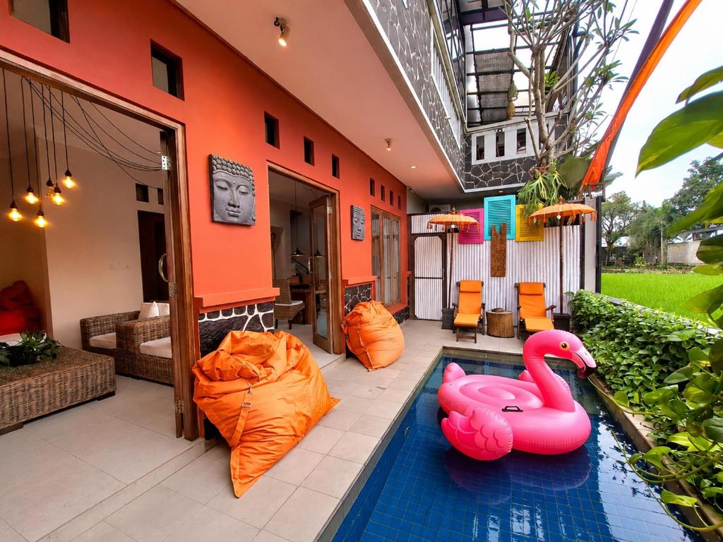 a swimming pool with inflatable flamingos in a house at Villa Jogja Tropical in Yogyakarta