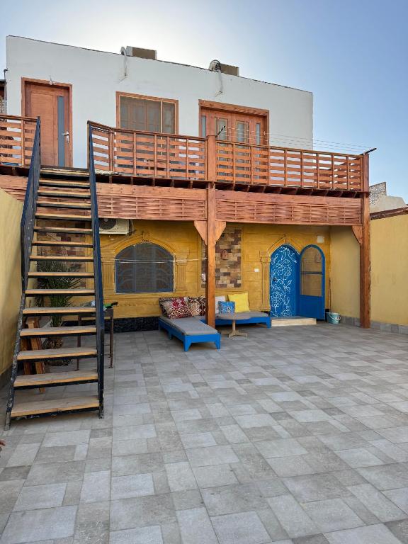 a building with a deck and a staircase in a courtyard at Blue Villa in Lighthouse in Dahab
