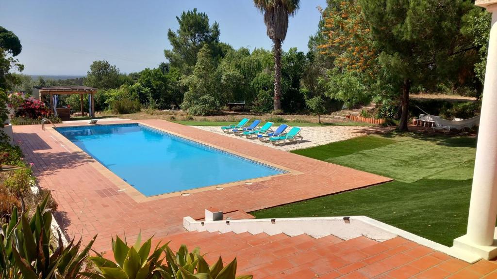 a swimming pool in a yard with two lounge chairs at Monte da Cardela Nova in Melides