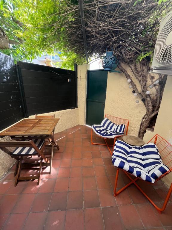 a patio with chairs and a table and a wooden table at Une pause vacances in Bandol
