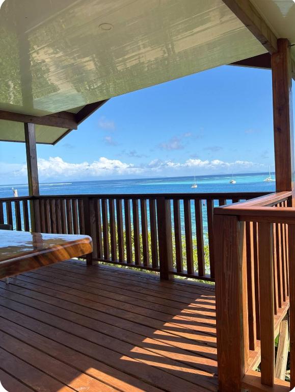 a deck with a table and a view of the ocean at Bungalow Omati in Tahateao