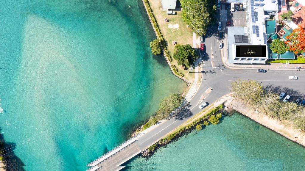 an aerial view of a road next to a body of water at HaKu in Brunswick Heads