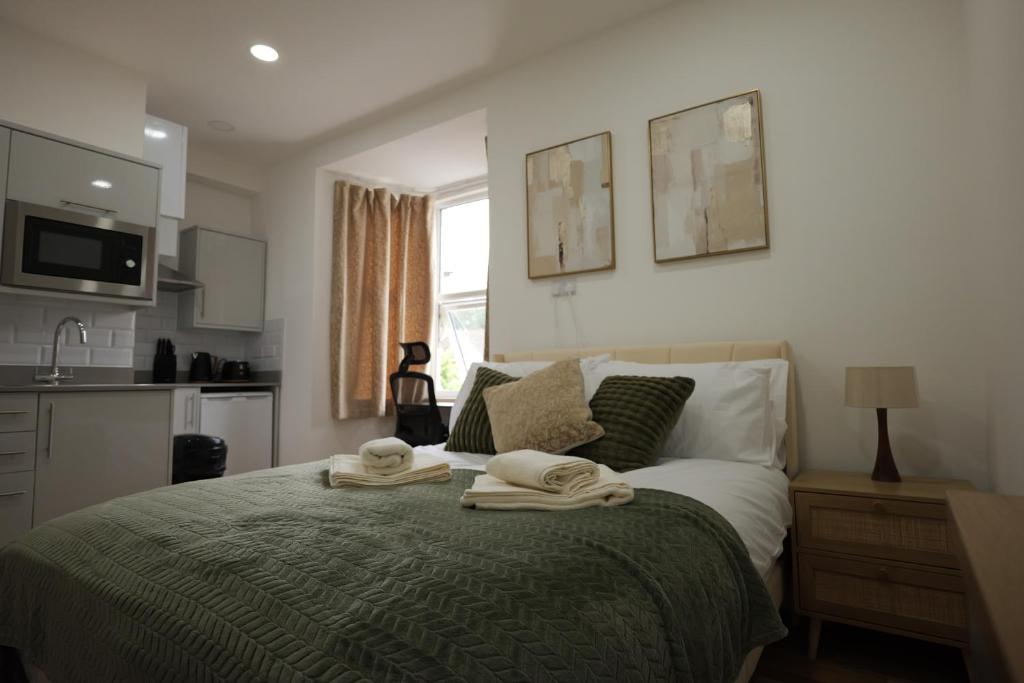 a bedroom with a bed with towels on it at Deaf Property - Woolwich Elizabeth Line Studios in Woolwich