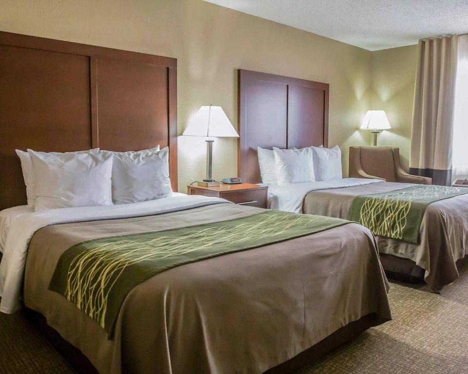 a hotel room with two beds and a chair at Comfort Inn Morris I-80 in Morris