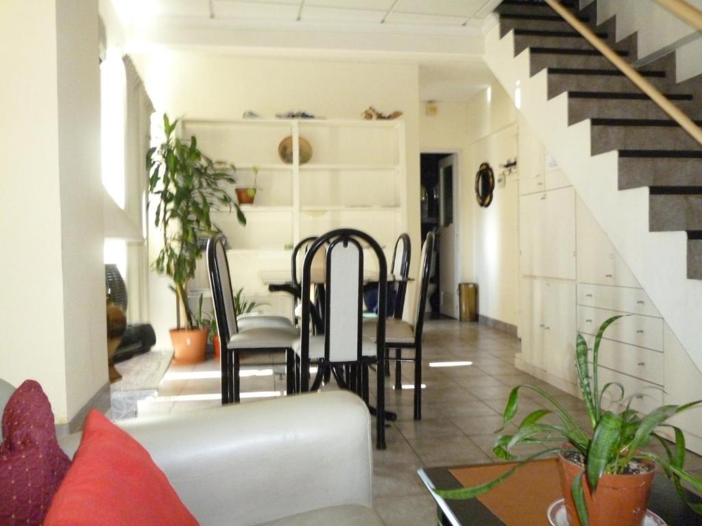 een woonkamer met een tafel en stoelen en een trap bij Perla Italiano in Buenos Aires
