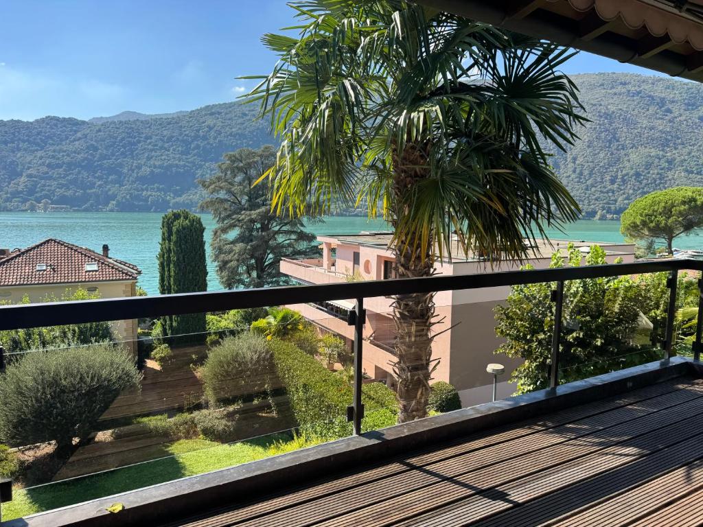 a view from the balcony of a house with a palm tree at Morcote Limone Suite mit traumhafter Seesicht in Morcote