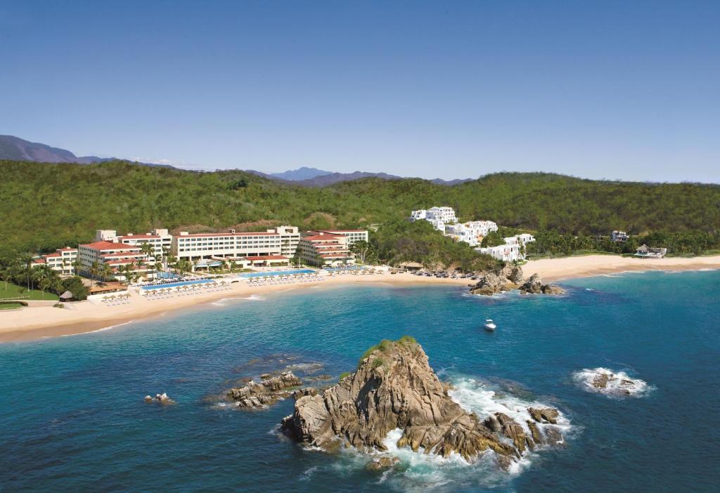 an aerial view of a beach with buildings and a mountain at Dreams Huatulco Resort & Spa in Santa Cruz Huatulco