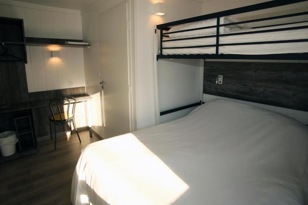 a bedroom with a white bed and a loft at Fasthotel Albertville in Albertville