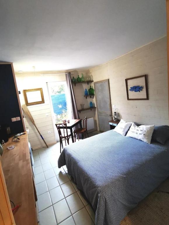 a bedroom with a bed and a table and chairs at Esprit d'Antan in Ploubazlanec