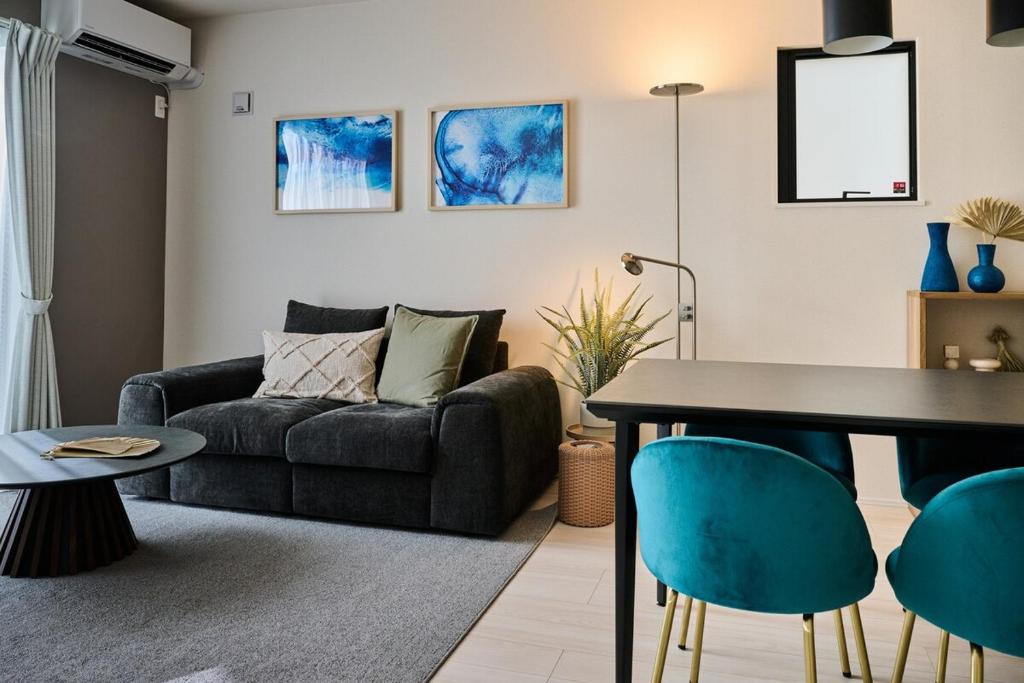 a living room with a couch and a table at White Breeze House in Ginowan