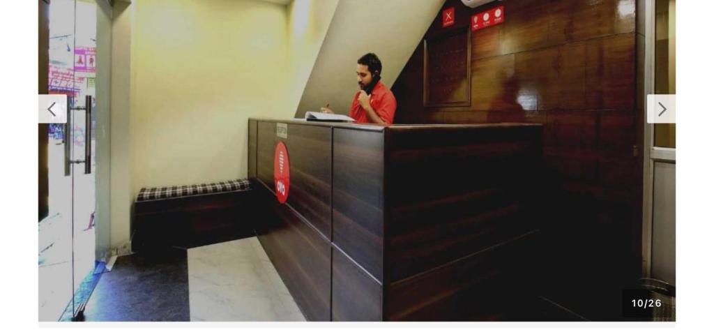 a man is standing at a counter in a room at Hotel O Alpine in Chandīgarh