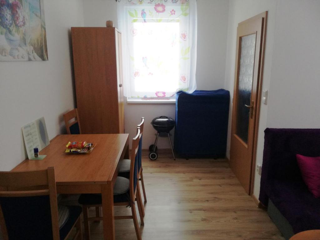 a dining room with a table and chairs and a window at Apartmán č. 8 Skalka in Donovaly