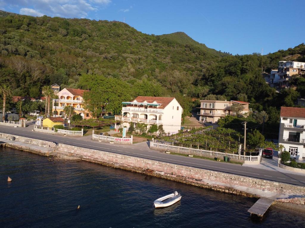 a boat in the water next to a road and houses at Stevovic Apartments - Brand New Apartments in Tivat
