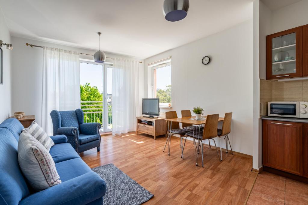 a living room with a blue couch and a table at Apartament Piastowska Elite in Gdańsk