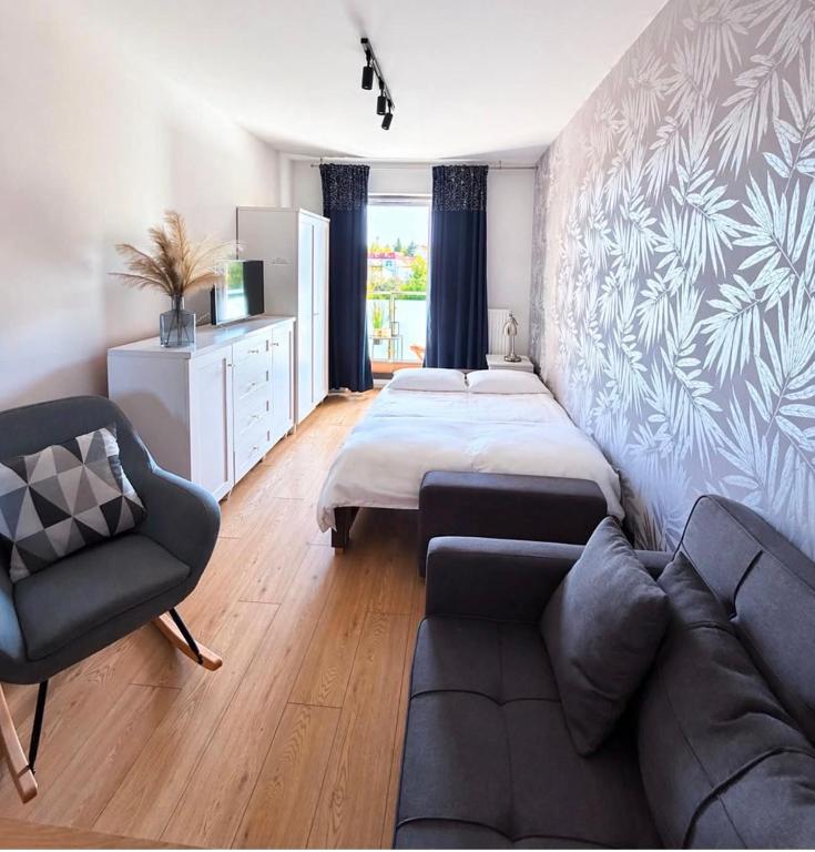 a living room with a bed and a couch at Apartament na Okrzei in Sandomierz