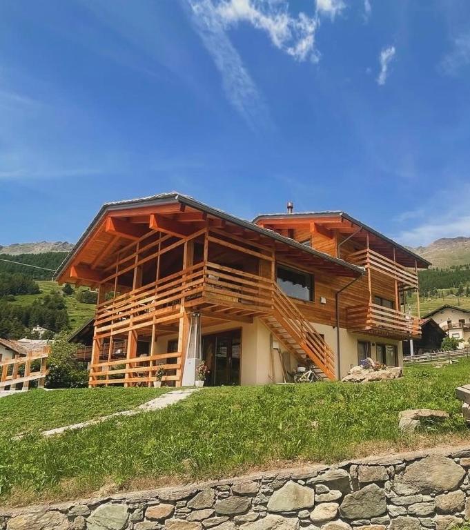 a large wooden house on top of a hill at B&B Eco Chalet Merlet in Champoluc