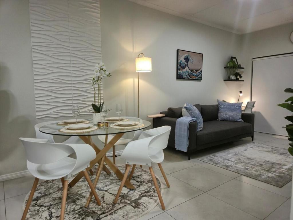 a living room with a table and a couch at The One Wave - 2 Bed Serenity meets Luxury in Midrand
