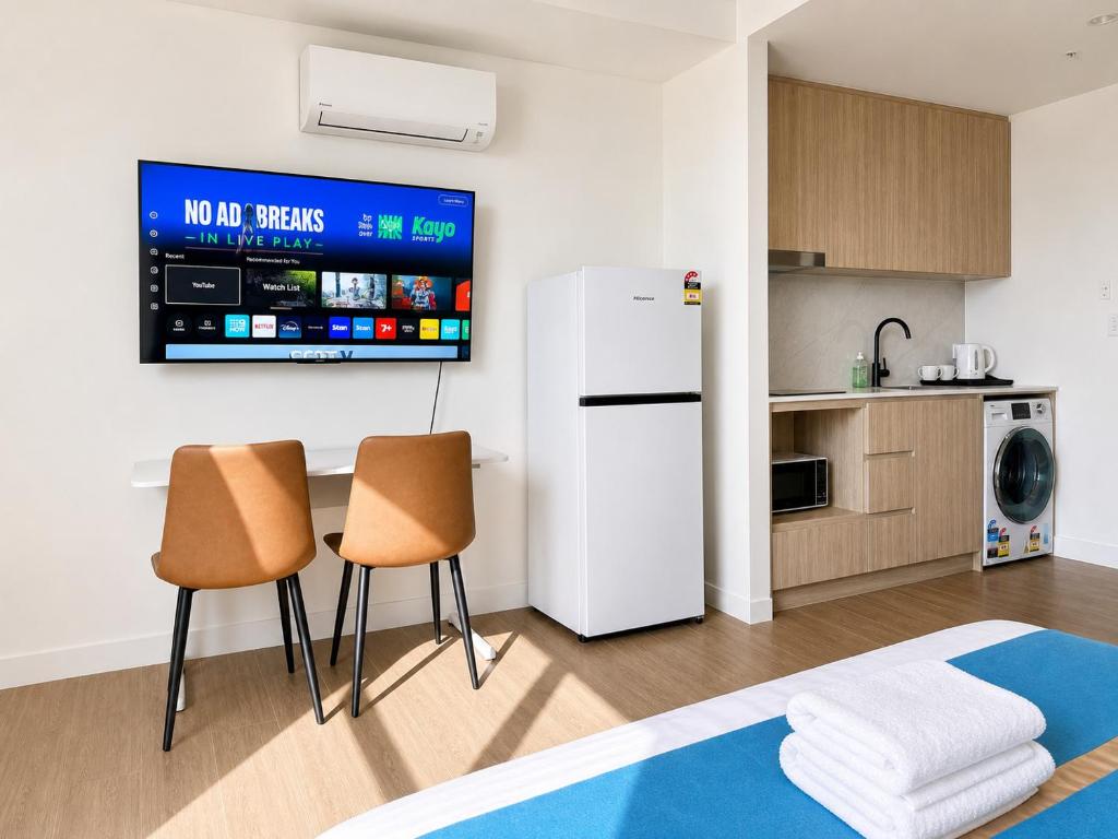 a kitchen with a white refrigerator and two chairs at Granville Studio Ensuite toilet and kitchen in Clyde