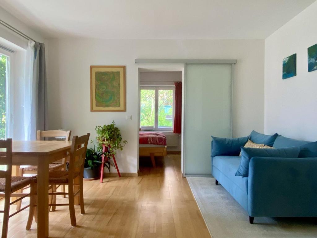 a living room with a blue couch and a table at Häuschen mit Gartenblick in Idstein