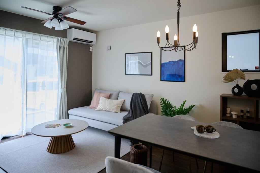 a living room with a couch and a table at Black Grove House in Ginowan